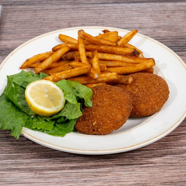 Huntington Deli & Market's crispy fried chicken cutlets with golden french fries, lettuce, and a lemon wedge.