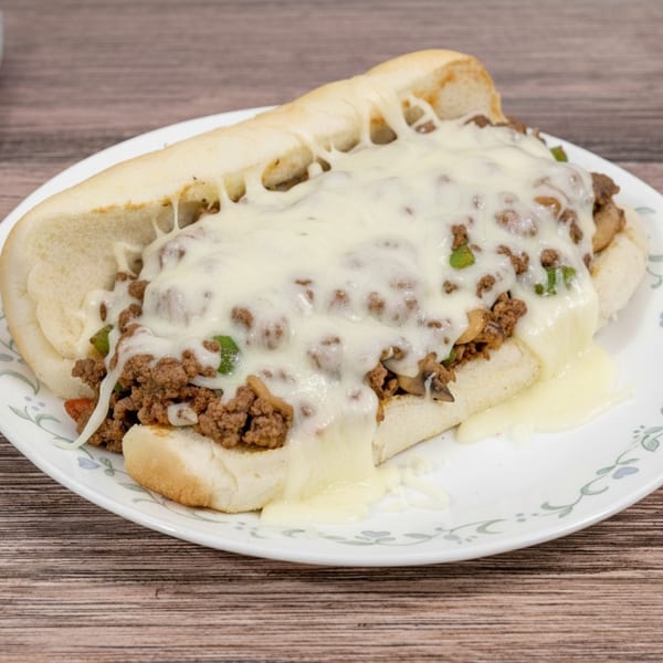 A Huntington Deli & Market cheesesteak with melted white cheese, ground meat, and green peppers.
